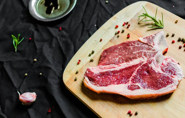 T ben biff av nötkött kött mot svart bakgrund — Stockfoto