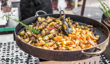 Bir sokak gıda pazarında biberiye pişirme ile kavrulmuş patates
