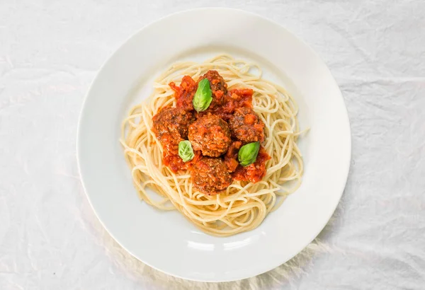Спагетти с фрикадельками в томатном соусе и листьях базилика — стоковое фото