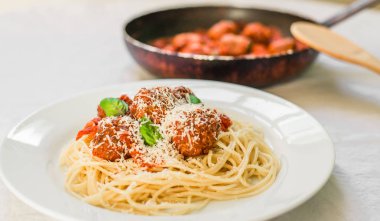 Domates soslu köfteli spagetti makarnası, üzerine düşen peynir