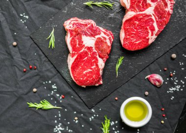 Siyah arka plan karşı baharat ve otlar ile Kaburga göz sığır eti biftek et