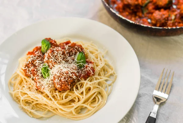 Паста-спагетти с фрикадельками в томатном соусе, сыр, падающий поверх него — стоковое фото