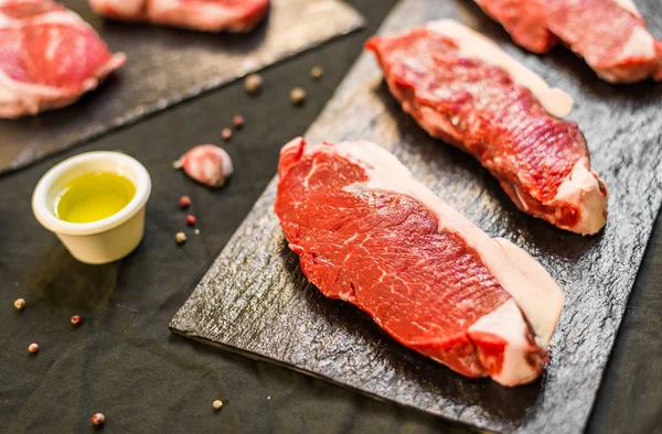 New York Strip Porterhouse biff nötkött kött mot svart bakgrund — Stockfoto