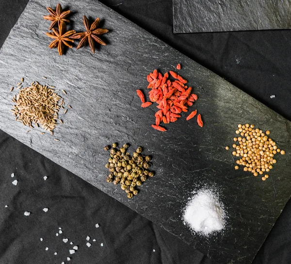 Velký výběr různých barevných kontrastních koření a semen na břidlici — Stock fotografie