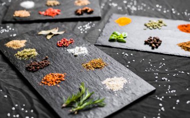 Arduvaz üzerinde farklı renkli kontrast baharatlar ve tohumlar büyük seçim