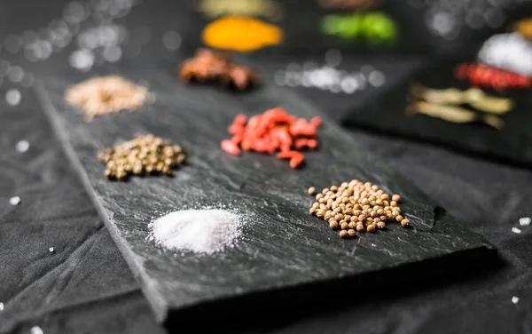 Velký výběr různých barevných kontrastních koření a semen na břidlici — Stock fotografie