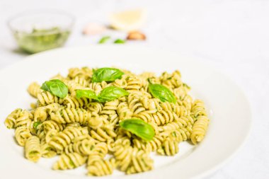 Beyaz arka plan karşı fesleğen ve peynir pesto ile Makarna