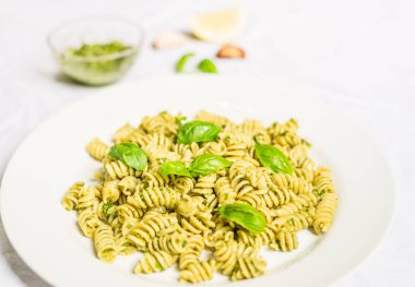 Beyaz arka plan karşı fesleğen ve peynir pesto ile Makarna