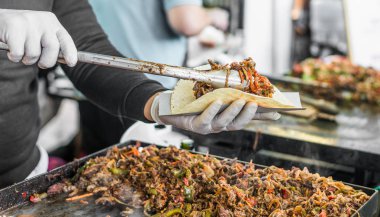 Bir sokak gıda pazarında Şef bir taco hazırlanıyor