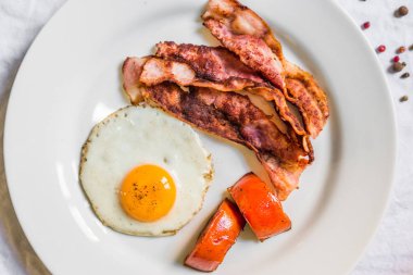 Beyaz arka plan karşı gevrek pastırma ve domates ile Kızarmış tavuk yumurta