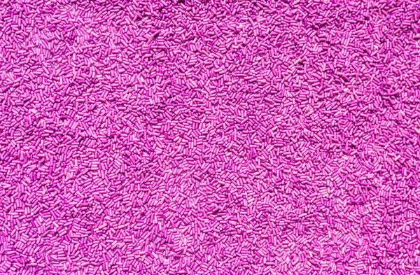 Achtergrond van kleurrijke paarse hagelslag. Voedsel textuur en patroon. — Stockfoto