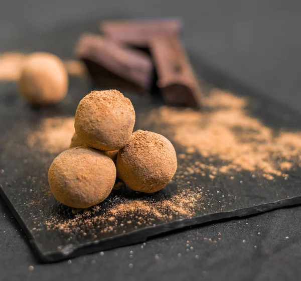 Конфеты с шоколадными трюфелями, покрытые какао-порошком на черном фоне . — стоковое фото