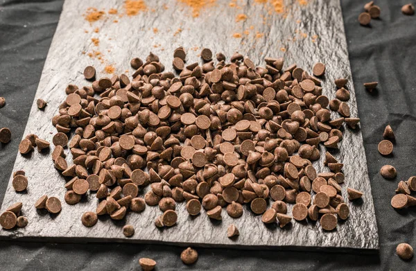 Chocolate com chips de chocolate contra fundo preto . — Fotografia de Stock