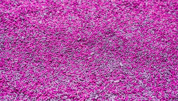 Achtergrond van kleurrijke paarse hagelslag. Voedsel textuur en patroon. — Stockfoto