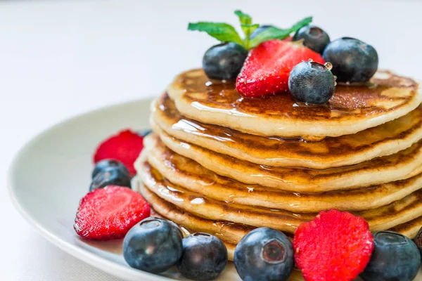 Amerikanische Pfannkuchen mit Honig vor weißem Hintergrund. — Stockfoto