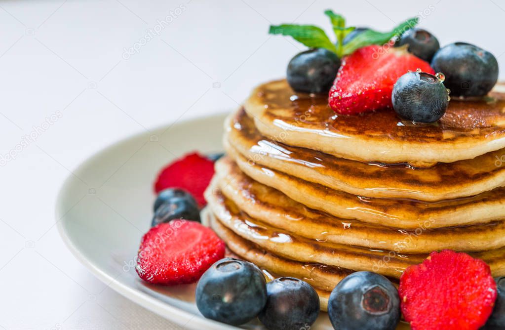 American pancakes with honey against white background.