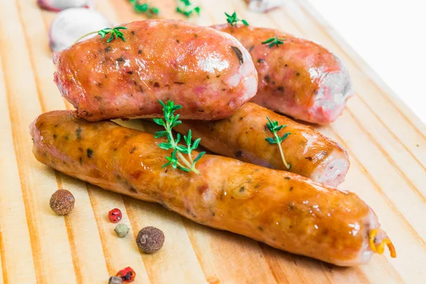 Salchichas de carne de chorizo a la parrilla en una tabla de madera . —  Fotos de Stock