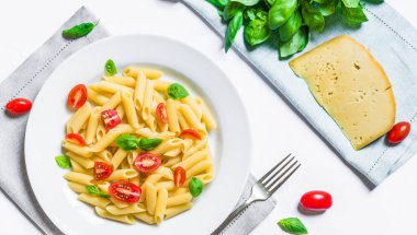 Kiraz domates ve fesleğen yaprakları ile renkli penne rigate makarna çanak.