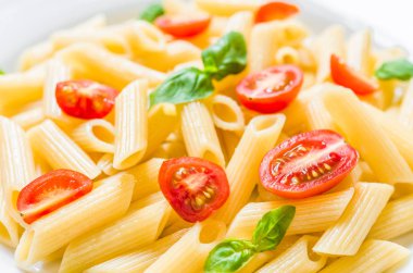 Kiraz domates ve fesleğen yaprakları ile renkli penne rigate makarna çanak.