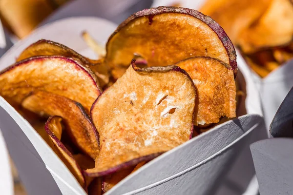 Édes burgonya chips francia krumpli egy kúp egy utcai élelmiszer-piac. — Stock Fotó