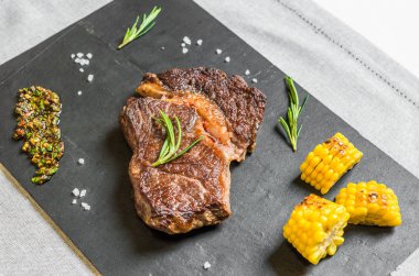 Siyah arka plan karşı chimichurri soslu ızgara kaburga göz biftek biftek et