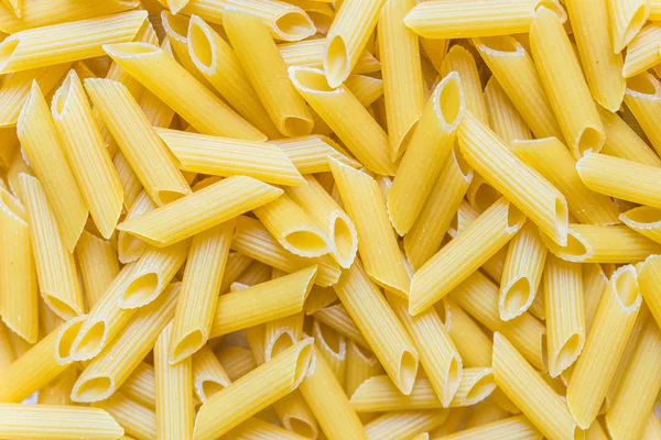 Colorful food background of penne rigate pasta. — Stock Photo, Image