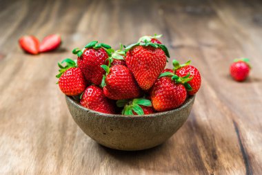 Ahşap arka planda taze renkli organik çilek kasesi. 