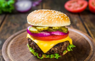 Tahta arka planda peynirli çizburger. Lezzetli fast food..