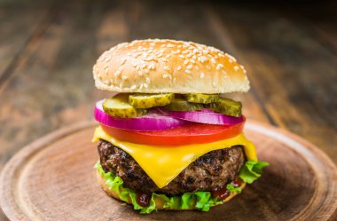 Tahta arka planda peynirli çizburger. Lezzetli fast food..