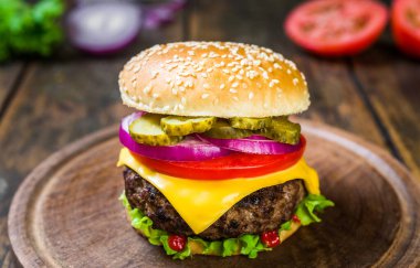 Tahta arka planda peynirli çizburger. Lezzetli fast food..