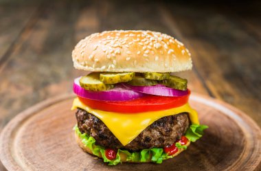 Tahta arka planda peynirli çizburger. Lezzetli fast food..