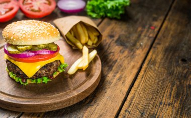 Tahta arka planda çizburger ve patates kızartması. Lezzetli fast food..