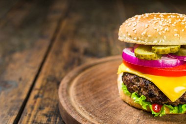 Tahta arka planda peynirli çizburger. Lezzetli fast food..