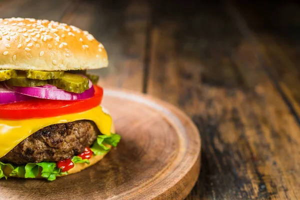 Hamburguesa de queso con queso sobre fondo de madera. Sabrosa comida rápida . — Foto de Stock