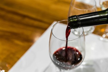 Şarap bardağına kırmızı şarap servisi yapan bir şarap garsonu. .