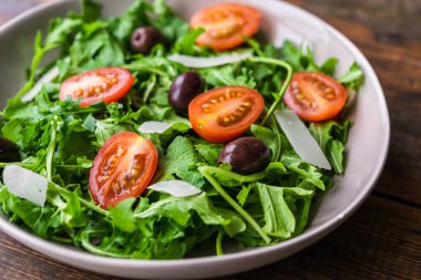 Roket salatalı salata kasesi, siyah zeytin ve vişneli domates.