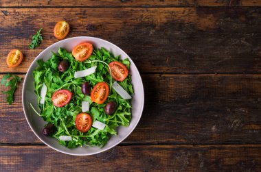 Roket salatalı salata kasesi, siyah zeytin ve vişneli domates.