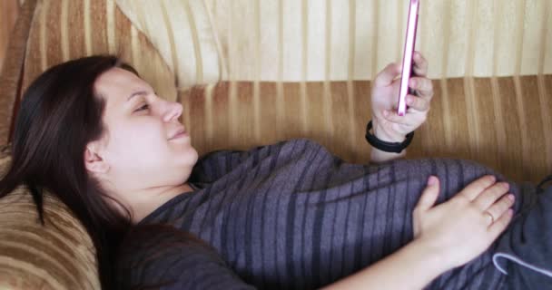 Chica embarazada con un teléfono inteligente — Vídeos de Stock