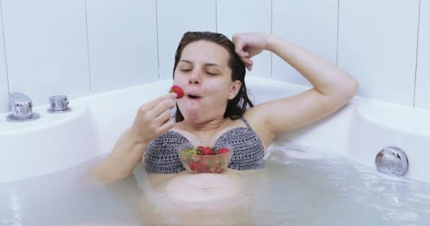 Беременная девушка ест клубнику — стоковое видео