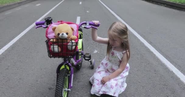 Девочка ремонтирует велосипед — стоковое видео