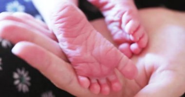 Bebek bacakları tutan kadın