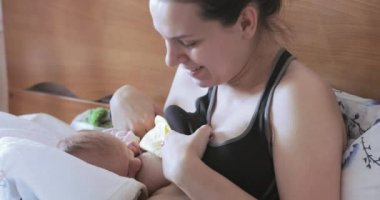 Erkek bebek yatakta emzirir
