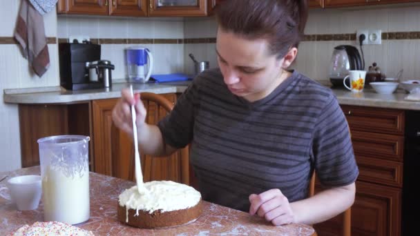 Flickan täcker påsk kakan med glasyr — Stockvideo
