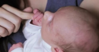 Anneler parmak için tutunmuş erkek bebek