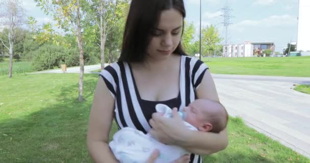 Jonge moeder met baby in het park — Stockvideo