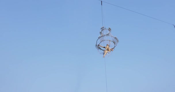 Chica acróbata en vestido blanco en el aire por encima de la calle en una gran lámpara de araña en la cuerda — Vídeo de stock