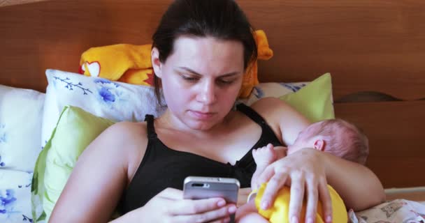 Madre lactante con smartphone — Vídeos de Stock