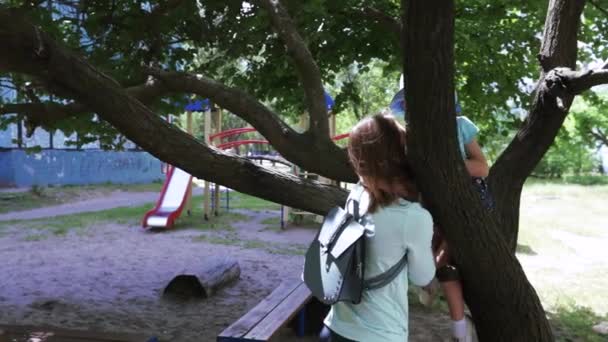 Девочка мамочка сидит на дереве — стоковое видео