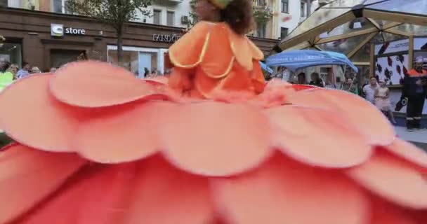 Dansare på styltor i dräkter av färgglada stora blommor — Stockvideo
