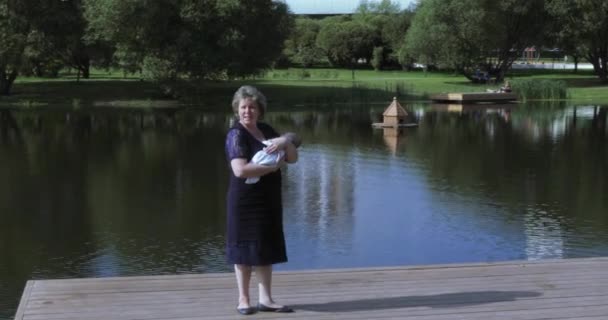 Мама с дочерью на пруду — стоковое видео
